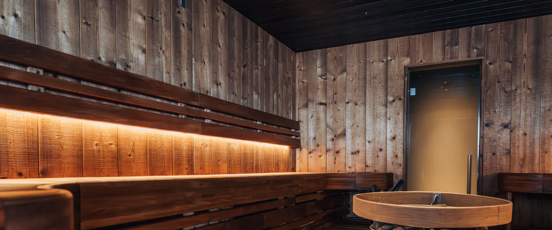 Ruhiger Saunaraum aus Holz mit warmem Licht als Geschenkidee für einen Wellness-Gutschein