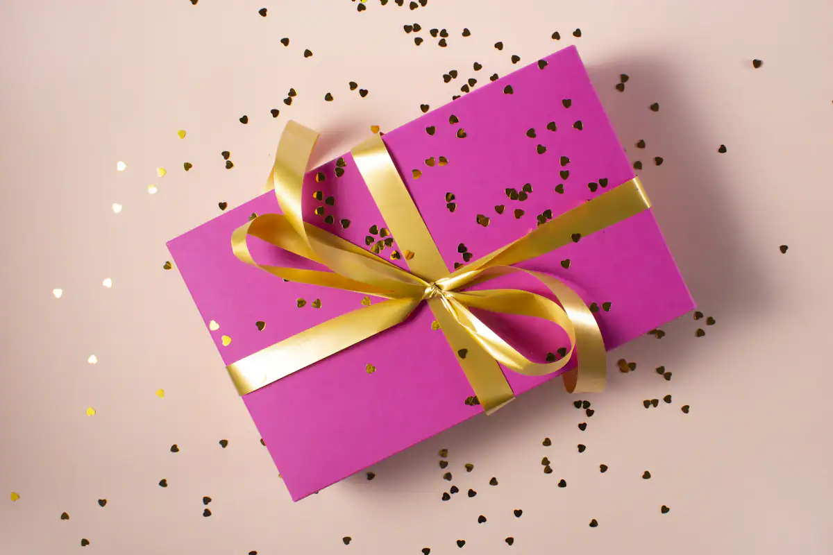 Wellness-Gutschein verpacken Rosa Geschenk mit goldener Schleife für einen Wellness-Gutschein